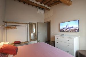 a bedroom with a bed and a tv on the wall at La finestra sulla Torre in Siena