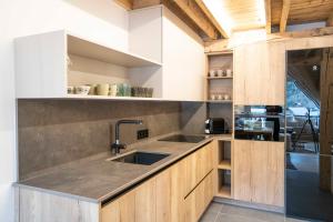 a kitchen with wooden cabinets and a sink at Muntanyó Luxury Lodge con sauna, parking y guardaesquis en Ruda in Tredós