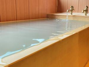 a bath tub with water coming from two faucets at Kashoutei Hanaya in Noboribetsu