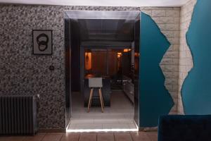 a room with a hallway with a table and a stool at Maison de Ville restylée avec jardin, proche gare in Dunkerque