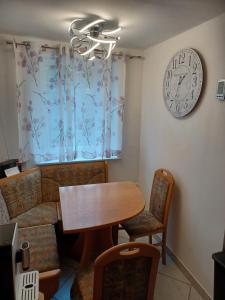uma sala de jantar com uma mesa e um relógio na parede em Seidis Apartment mit Küche 