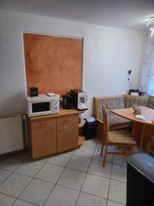 uma cozinha com um micro-ondas num balcão com uma mesa em Seidis Apartment mit Küche 