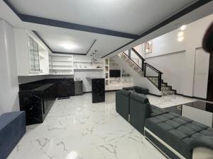 a living room with a couch and a staircase at Pike Guest House in Dagupan