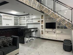 ein Wohnzimmer mit einem Sofa und einem Schreibtisch mit einem TV in der Unterkunft New build beautiful Apartment in Dagupan