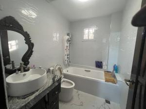 a bathroom with a sink and a bath tub at Pike Guest House in Dagupan