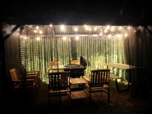 a stage with chairs and a table and lights at 一棟貸切 森のお風呂とアウトドアサウナ 日光雪月花 in Nikko