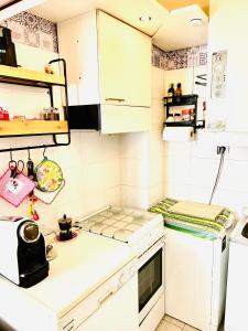uma pequena cozinha com armários brancos e um fogão em Intero appartamento Bolohouse em Bolonha