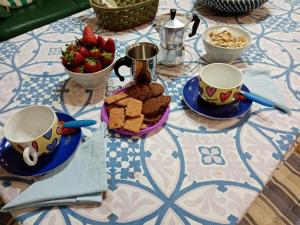 a table with cookies and a bowl of strawberries on it at B&B Il Faraglione Bianco in Vieste