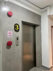 un ascensore con un cartello numero tre su un muro di Aowmana Hotel a Makkasan