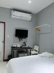 1 dormitorio con 1 cama y escritorio con TV en Aowmana Hotel en Makkasan