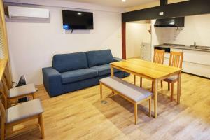 sala de estar con sofá azul y mesa en WAY SHIRAKAWAGO - Private, Free Parking and Newly Opened 2022 WAY SHIRAKAWAGO, en Shirakawa
