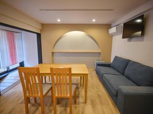 un soggiorno con un tavolo e un divano blu di WAY SHIRAKAWAGO - Private, Free Parking and Newly Opened 2022 WAY SHIRAKAWAGO a Shirakawa