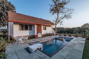 a house with a swimming pool in a yard at SaffronStays Mariposa by the River Sol, Karjat in Karjat