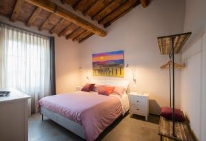a bedroom with a bed and a painting on the wall at La finestra sulla Torre in Siena