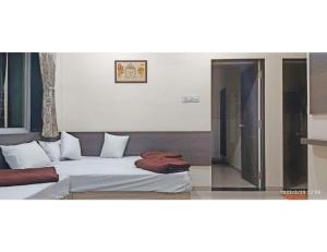 um quarto com uma cama e uma porta de vidro deslizante em The Rudra Homestay, Garudeshwar em Garudeshwar