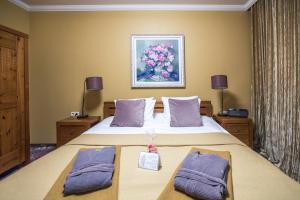um quarto com uma cama grande e almofadas roxas em Baltvilla em Baltezers