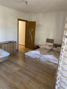 1 dormitorio con 2 camas y puerta de madera en Апартамент за гости en Devin