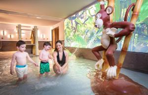 una mujer y tres niños en un parque acuático en Golden Tulip Aix les Bains - Hotel & Spa, en Aix-les-Bains