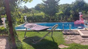 a hammock sitting in the grass next to a pool at Sunny houm in Nesebar +13 photos
