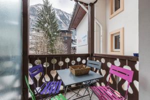 a table and chairs on a balcony with a window at Rivière 210 - Happy Rentals in Chamonix