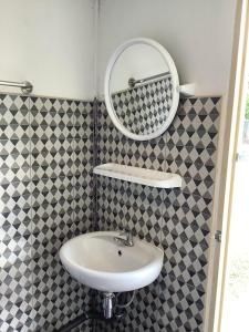 La salle de bains est pourvue d'un lavabo et d'un miroir. dans l'établissement Paa & Michaels Resort, 