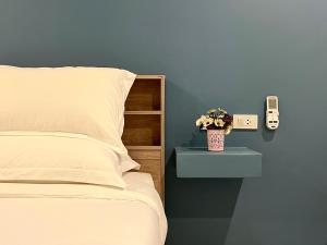 une chambre avec un lit et un téléphone sur une table de chevet dans l'établissement THE NICE, à Patong Beach