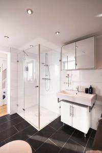 a white bathroom with a shower and a sink at Pfälzer Herzel in Neustadt an der Weinstraße