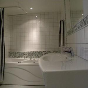 Baño blanco con bañera y lavamanos en Glimminge Bed & Breakfast, en Simrishamn