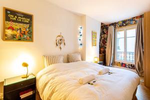 1 dormitorio con 1 cama blanca grande y ventana en GuestReady - Excellent stay in the 11th arr en París