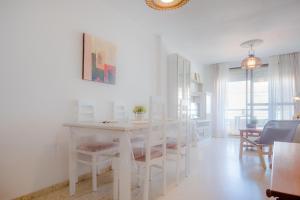 a white dining room with a white table and chairs at La Barrosa con vistas al mar in Novo Sancti Petri