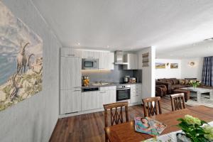 a kitchen and living room with a table and chairs at Hotel Bayerisch Meran in Bad Feilnbach