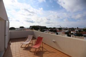 two chairs on a balcony with a view of a city at Villa Marina Calan Blanes in Cala en Forcat