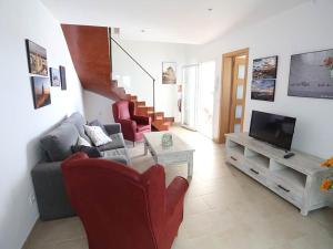 a living room with a couch and a tv at Villa Marina Calan Blanes in Cala en Forcat