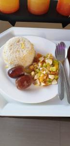 un plato blanco de comida con arroz y verduras en Wency Amor Hotel, en Sablayan
