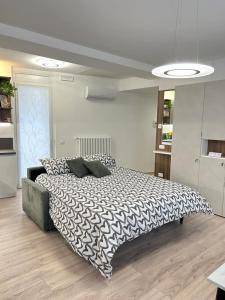 una camera da letto con un letto con un piumone bianco e nero di Codroipo square a Codroipo