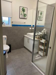 uma casa de banho com um chuveiro, um lavatório e um WC. em Comfy nest 4 bed room family house em Melton South