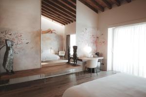 a bedroom with a bed and a desk and a mirror at Borgo Corsignano in Poppi