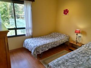 sypialnia z 2 łóżkami i oknem w obiekcie Casa con vistas a 100 metros de una playa en Panxón w mieście Nigrán
