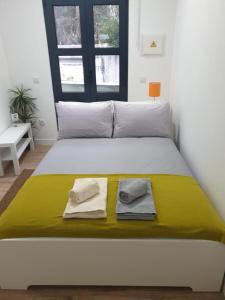 a bedroom with a bed with two towels on it at Bonjóia Porto Guest House in Porto