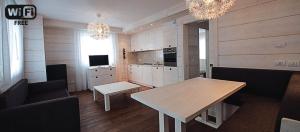 a living room with a table and a kitchen at Zoncolan Laugiane in Sùtrio