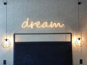 Ein Neonschild, auf dem ein Traum an einer Wand hängt. in der Unterkunft Apartament Biała Perła in Heudorf