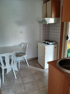 Garsonjera في زغرب: مطبخ صغير مع طاولة وكراسي وموقد