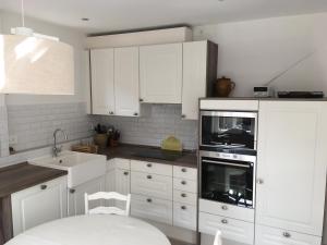 a kitchen with white cabinets and a sink and an oven at Waschhaus in Ditfurt