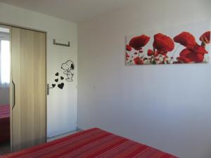 a bedroom with a bed and a picture of red roses at NICE NORD 2 PIECES CALMES,WIFI,CLIM,BALCON,PARKING in Nice