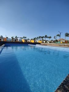 a large blue swimming pool with palm trees in the background at Mountain N Lake Resort in Igatpuri