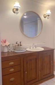 a bathroom with a sink and a mirror at Enchanting Retreat - The English Cottage at Tamborine Mountain in Mount Tamborine