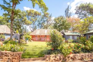 einen Garten mit einem Haus im Hintergrund in der Unterkunft Rudi House in Msaranga