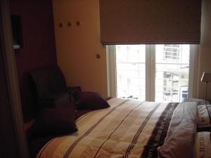 een slaapkamer met een groot bed en een raam bij Luxe appartement, zeezicht, garage en topligging in Oostende