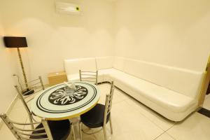 Habitación con sofá, mesa y sillas. en Hotel Darbar-E-Khas A member of Crimson Hotels en Bareilly