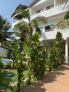 a building with palm trees in front of it at Villa Luxury Baguida in Lomé